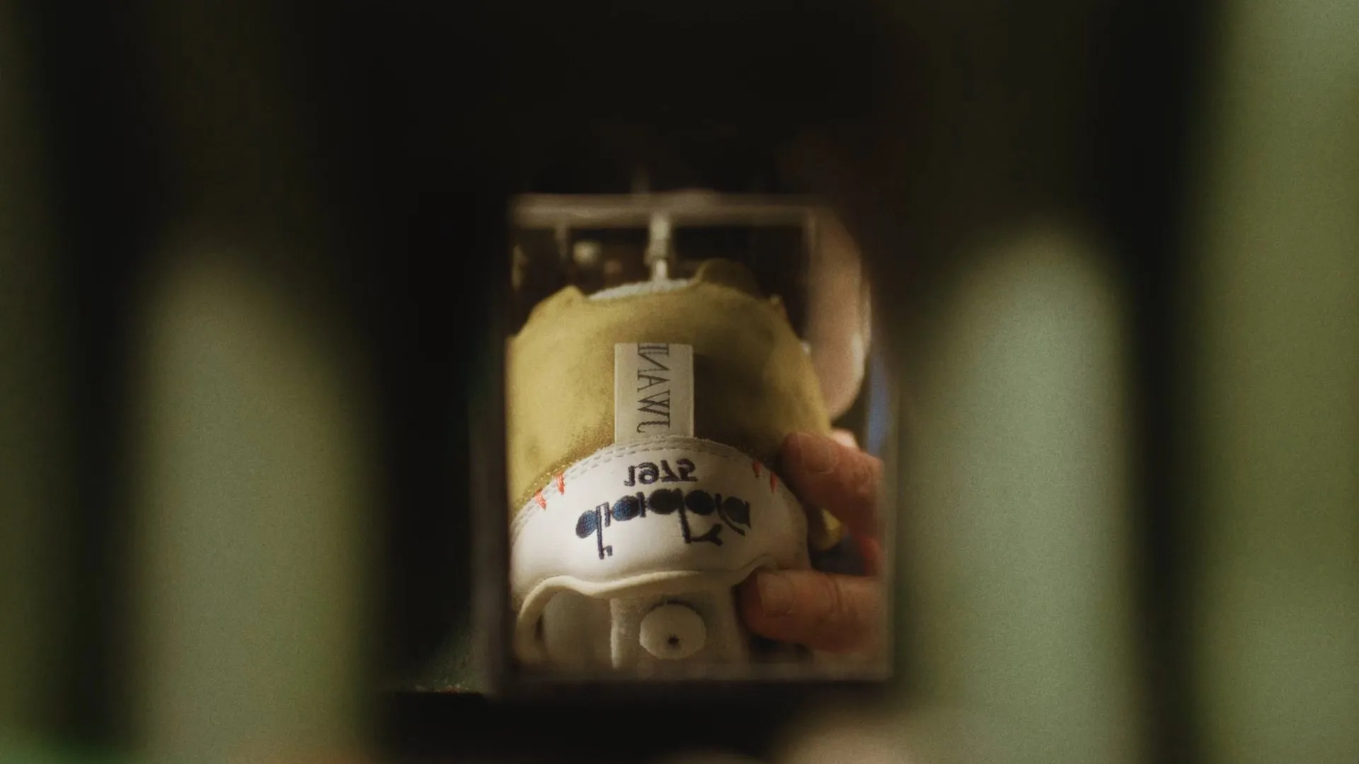 A Diadora shoe inside a testing machine, seen through the frame