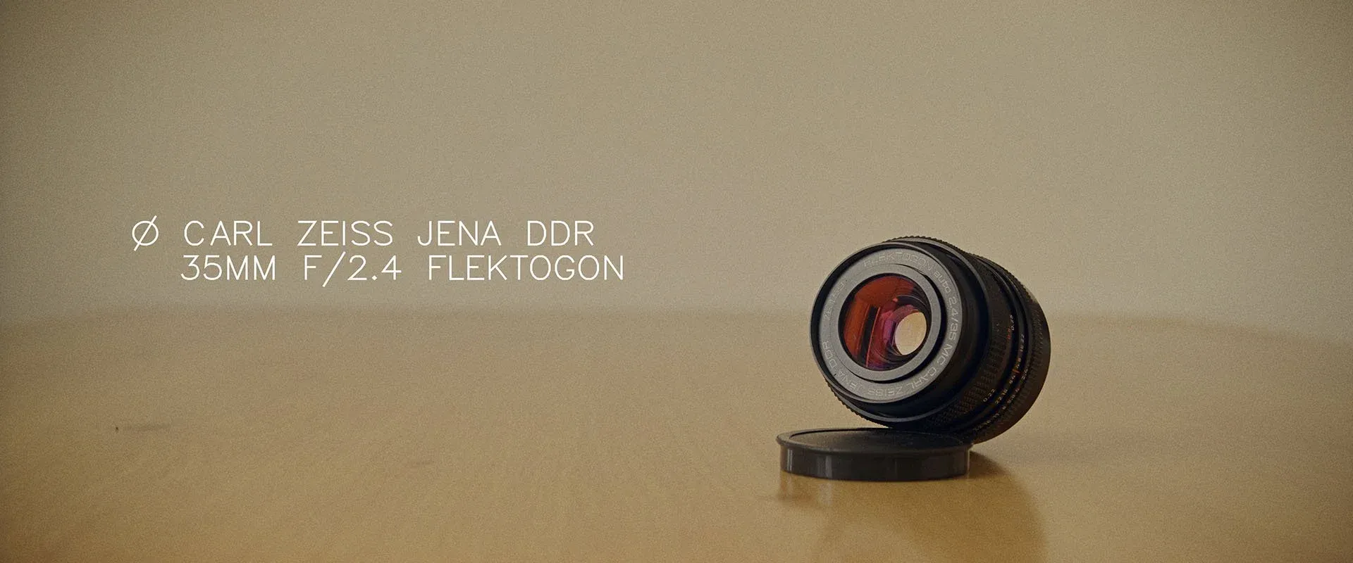 Carl Zeiss Jena 35mm f/2.4 Flektogon lens standing on a wooden table