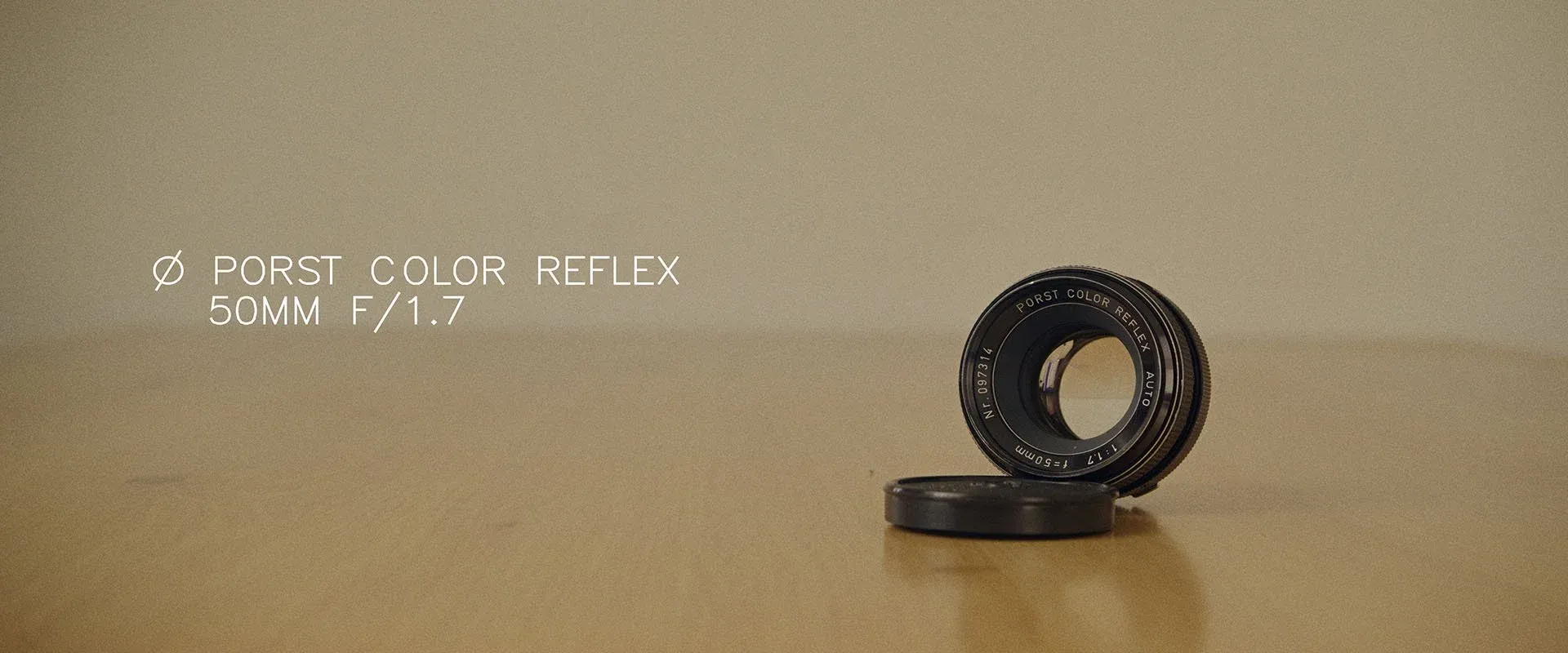 Porst Color Reflex 50mm f/1.7 lens standing on a wooden table