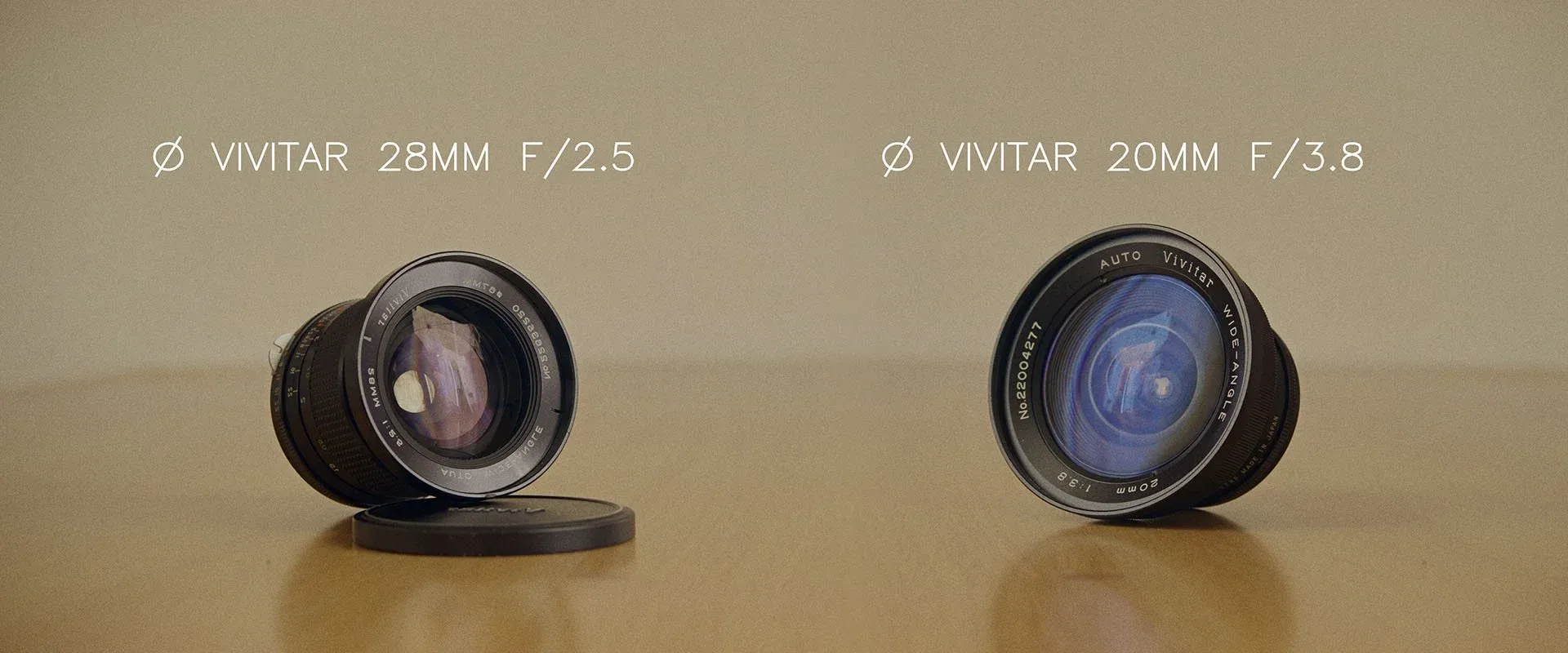 Vivitar 28mm f/2.5 and 20mm f/3.8 wide-angle lenses side by side on a table
