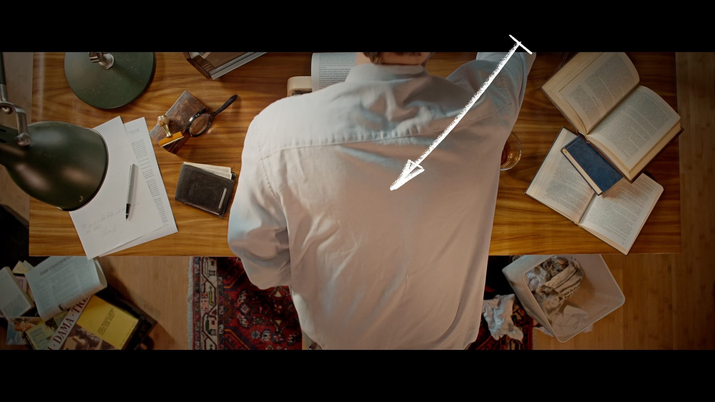 Next shot at the typewriter desk: a man in a white shirt moves back from the same spot, an arrow marking the direction